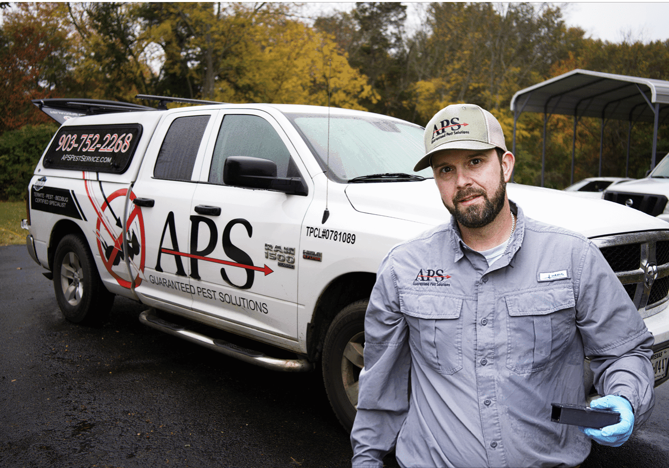 One of the APS technicians standing confidently in front of a service truck, ready to do some pest control.